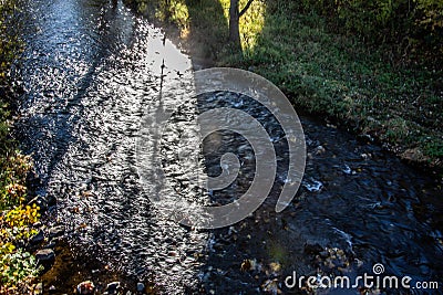 Autumn forest is intersected by a blue river Stock Photo