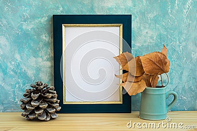 Autumn frame mockup, blue and golden border, tree branch with dry leaves in pitches, pine cone, concrete wall background, rustic Stock Photo