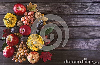 Autumn fruits and vegetables background. Harvest of ripe apples, grapes, plums, nuts and pumpkins on a dark wooden background. Stock Photo