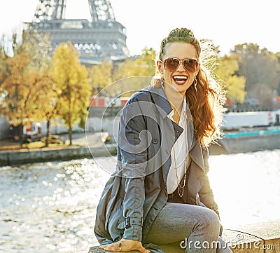 Portrait of happy elegant woman sitting on the parapet n Paris Stock Photo