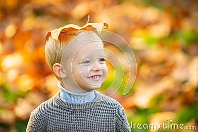 Autumn happy child have fun and playing with fallen golden leaves. Cute little boy enjoy autumn nature has happy face Stock Photo