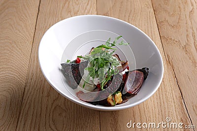 Autumn hot salad with deep fried beetroot, onion, tomato and nuts Stock Photo