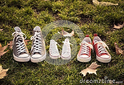 Autumn image of family shoes sneakers gumshoes on grass in sunset light in outdoors family lifestyle Stock Photo