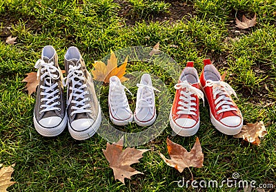 Autumn image of family shoes sneakers gumshoes on grass in sunset light in outdoors family lifestyle Stock Photo