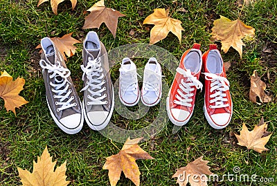 Autumn image of family shoes sneakers gumshoes on grass in sunset light in outdoors family lifestyle Stock Photo