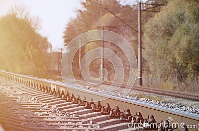 Autumn industrial landscape. Railway receding into the distance among green autumn trees Stock Photo