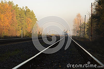Autumn Landscape Dark Railway with Shining Rails and Bright Forest Stock Photo