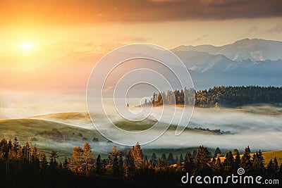 Autumn landscape image with sunrise or sunset, beautiful fog on meadow and mountain on background Stock Photo