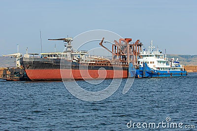 Autumn landscape, river, Works carried out on the river, riverboats, sunny day, wind raises the waves, dark lead color of water Stock Photo