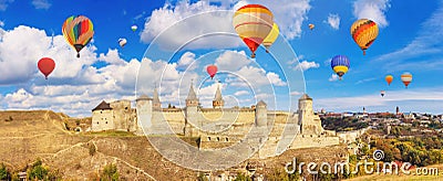 Autumn landscape - view of a medieval fortified castle on a hill with flying the hot air balloons Stock Photo