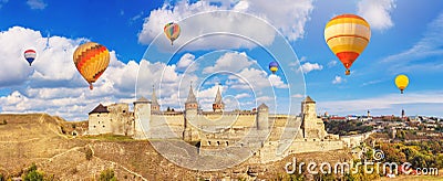 Autumn landscape - view of a medieval fortified castle on a hill with flying the hot air balloons Stock Photo