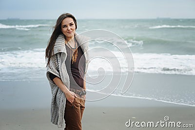 Autumn lifestyle fashion portrait of young stylish hipster woman walking on a sea beach Stock Photo