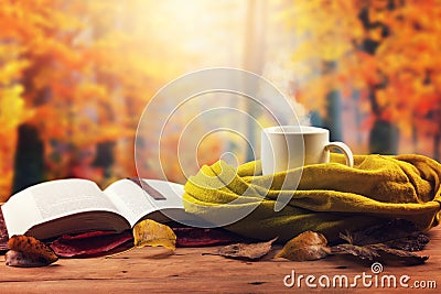 Autumn mood - opened book, scarf and hot drink on the table Stock Photo