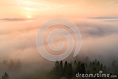 Autumn morning. Fog over valley in mountains illuminated by rising sun. Stock Photo