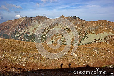 Autumn mountain coloured to orange and silhouettes of people Stock Photo