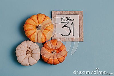 Autumn October flat lay. Orange mini pumpkins and calendar date in wooden frame. Halloween day. Blue background. Oak leaves. Fall Stock Photo