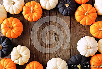 Autumn pumpkin frame in Halloween colors orange, black and white over rustic wood Stock Photo