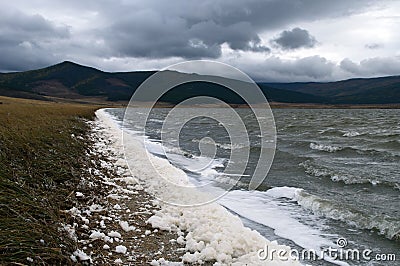 Wind swept landscape with spume along water`s edge Stock Photo