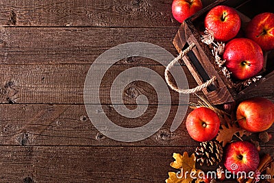 Autumn side border of apples and fall ingredients with crate on a rustic wood background Stock Photo