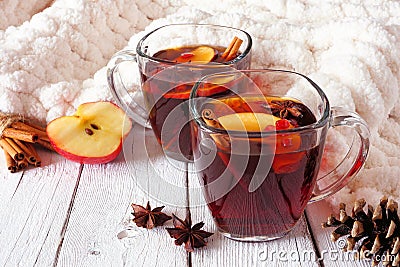 Autumn spiced tea with apples and pomegranates, side view against white wood background with cozy blanket Stock Photo