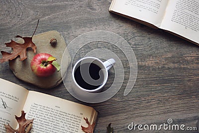 Autumn still life with apple, coffee, open books and leaves over rustic wooden background, copy space, horizontal, aerial view Stock Photo