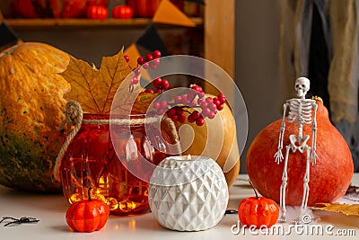 Autumn still life with pumpkin, candles, maple leaves and a skeleton Stock Photo