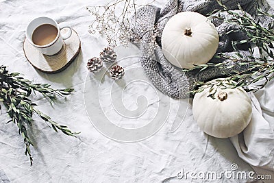 Autumn styled photo. Feminine Halloween desktop scene. Cup of coffee, eucalyptus, pine cones, white pumpkins and Stock Photo