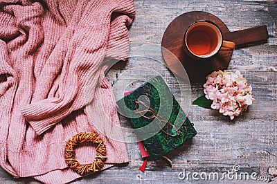 Autumn or summer garden table top view with cozy sweater, coffee, glasses, sketch book, dried hydrangea flowers Stock Photo