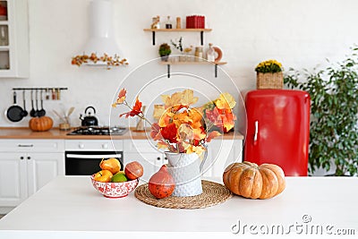 Autumn table with vegetables in kitchen. red and yellow leaves in the vase and pumpkin on white background Stock Photo