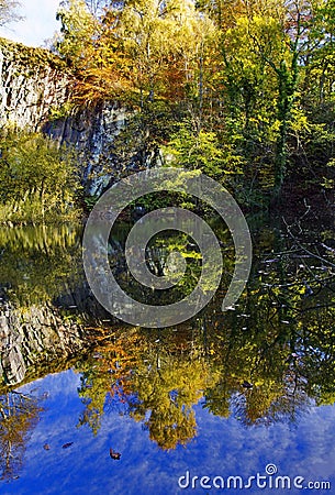 Autumn Trees reflected in the stillness of quary pool Stock Photo