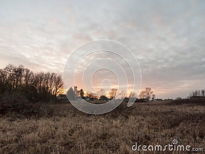 autumn winter dead grass field sunset grey overcast sky Stock Photo