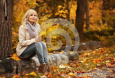 Autumn Woman. Fall. Blonde Beautiful Girl with Yellow Leaves Stock Photo