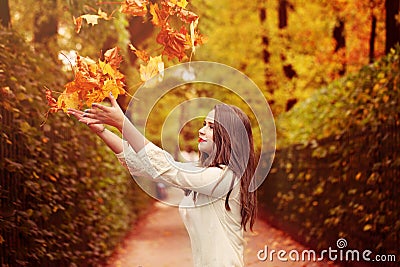 Autumn Woman Outdoors. Woman Fasion Model throwing Up Fal Stock Photo