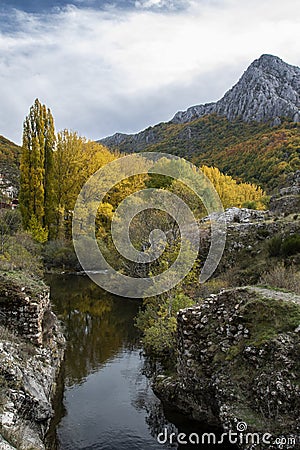 Autumnal landscape on the CurueÃ±o river. Cueto Ancino in the background, LeÃ³n, Spain Stock Photo