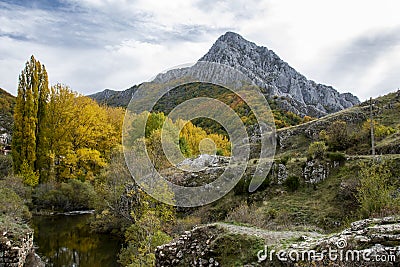 Autumnal landscape on the CurueÃ±o river. Cueto Ancino in the background, LeÃ³n, Spain Stock Photo