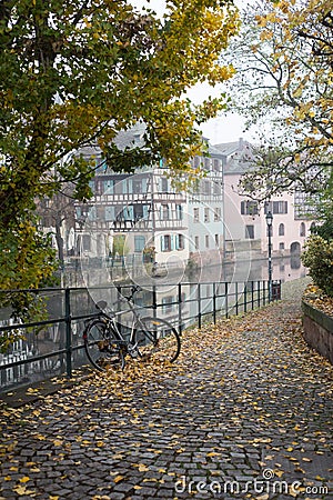 Autumnal trees and bicycle in border the Il river at the little france quarter Editorial Stock Photo