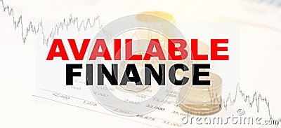 AVAILABLE FINANCE - financial text on the background of coins, chart in the early morning Stock Photo