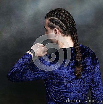 Attractive male model with braids posing in studio. Avantgarde, style, fashion concept. Stock Photo