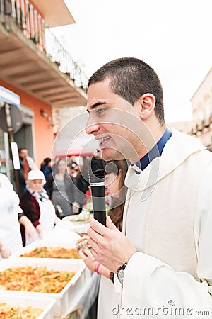 AVETRANA, ITALY - MARCH, 19, 2019. The priest blesses the food. Italian Easter tradition from Salento: Tria di St. Giuseppe, the Editorial Stock Photo