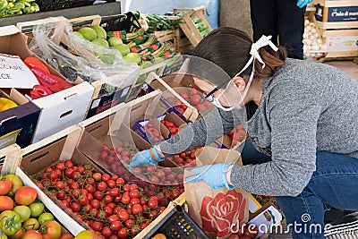 Avetrana, Italy, - Marth, 13, 2020. An Italian greengrocer serving a costumer wearing medical mask and gloves respecting health Editorial Stock Photo