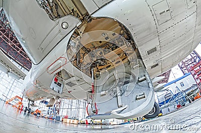 Aviation hangar with airplane, close-up landing gear of the airplane landing gear on maintenance repair. Stock Photo