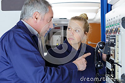 Aviation technician pointing at telephone inside aircraft Stock Photo