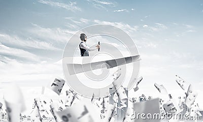 Aviator driving paper plane above business center Stock Photo