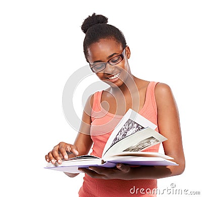 An avid reader at such a young age. Studio shot of a young african american girl reading a book and wearing glasses Stock Photo