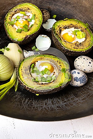 Avocado baked with quail eggs, fresh onion Stock Photo