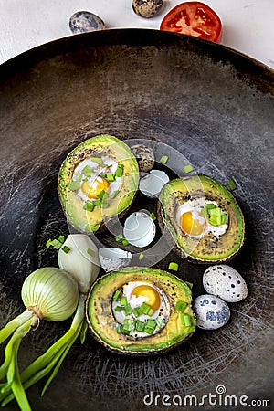 Avocado baked with quail eggs, fresh onion Stock Photo