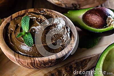 Avocado chocolate mousse in olive wooden bowl Stock Photo