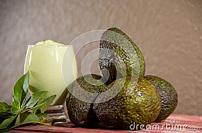 Avocado cream on the wooden surface with fresh fruits and leaves Stock Photo