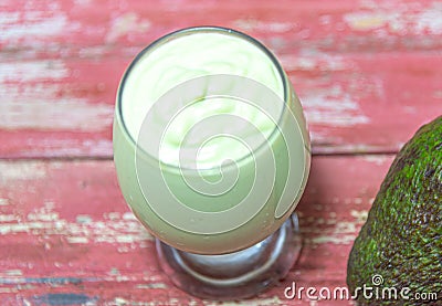 Avocado cream on the wooden surface with fresh fruits and leaves Stock Photo