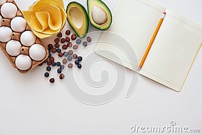 Avocado, dry berries, eggs and cheese, we are ready to write a new healthy recipe Stock Photo